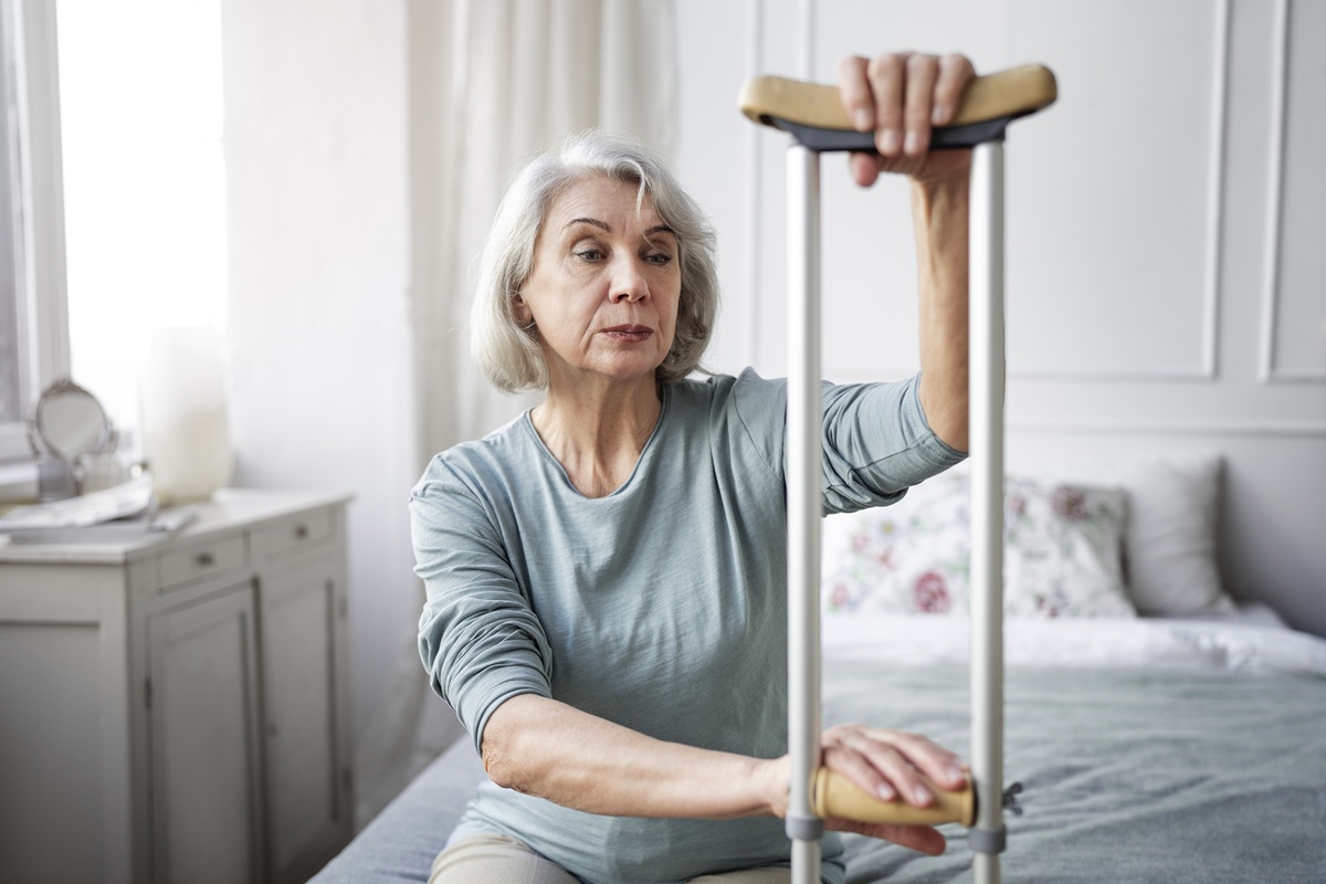 Fotografie starší ženy s berlou