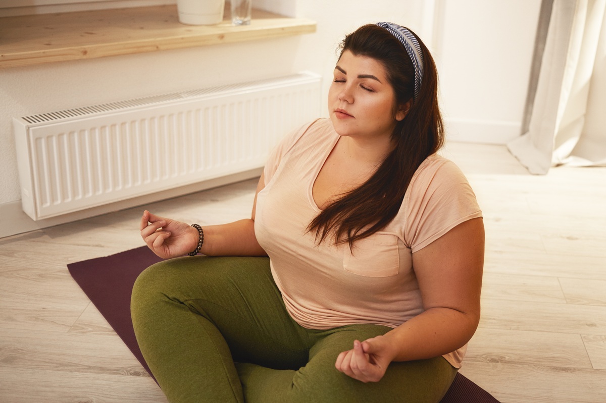 Fotografie ženy s nadváhou při meditaci